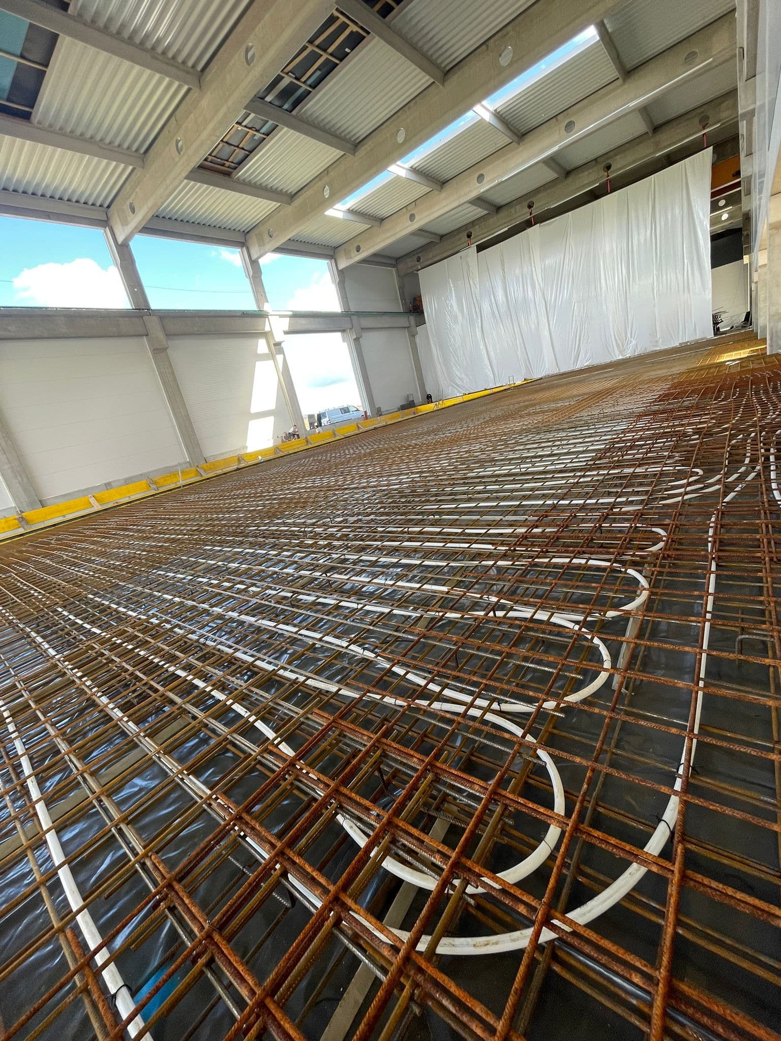 Vgradnja armaturne mreže v veliki industrijski hali.